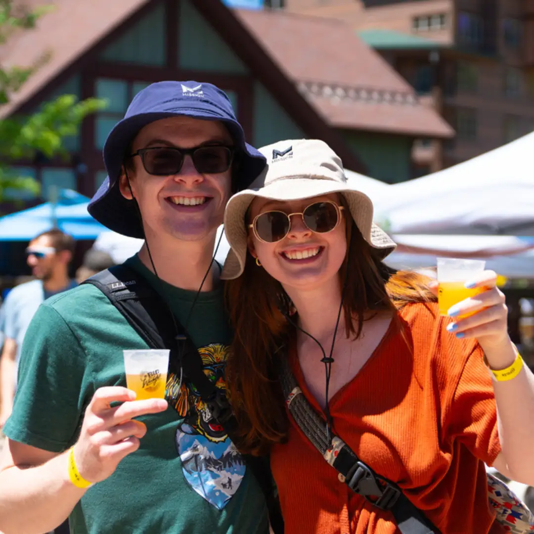 A couple in sunglasses smiling on Larimer Street