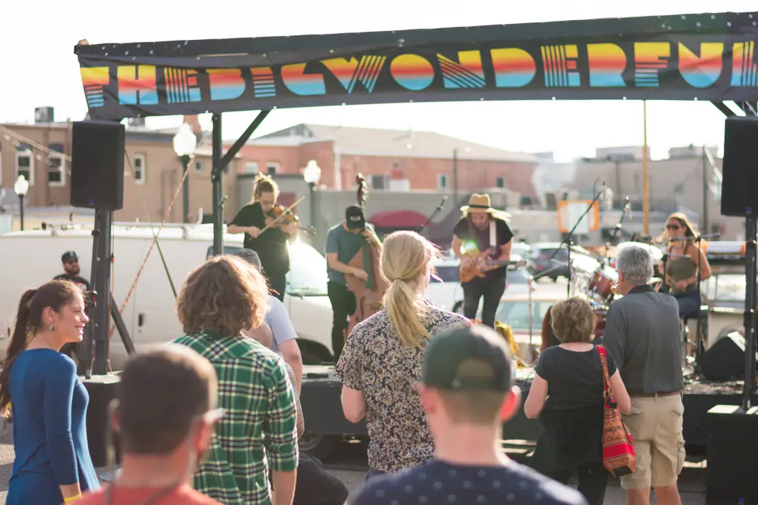 The crowd beside the Wonderful sign on a truck bed in Littleton