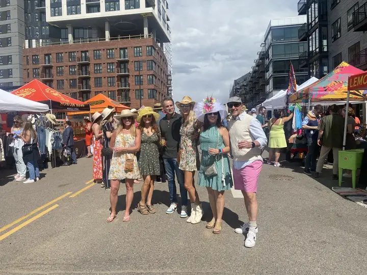 Friends in dresses and hats walking down the street.