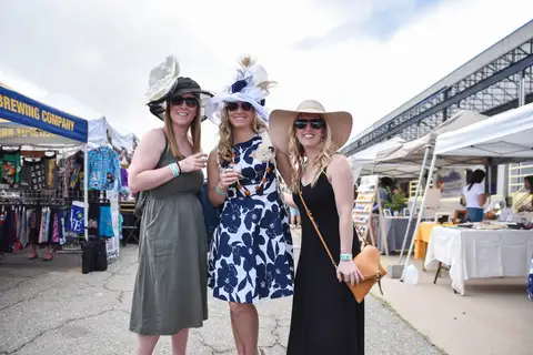Three women in hats and dresses.