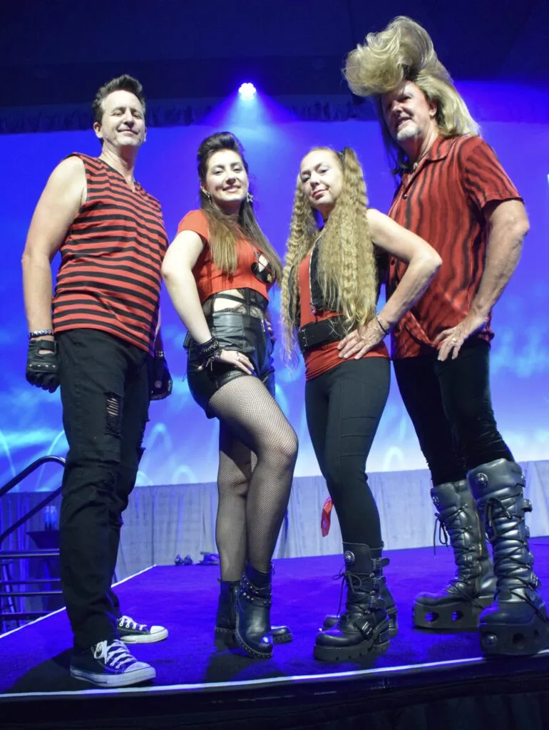 Ronnie Raygun & The Big Eighties on stage: four members in red and black 80s stage wear and towering teased hair