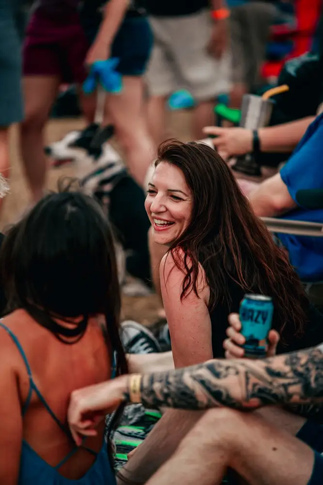 A woman in a crowd, eyes closed, singing.