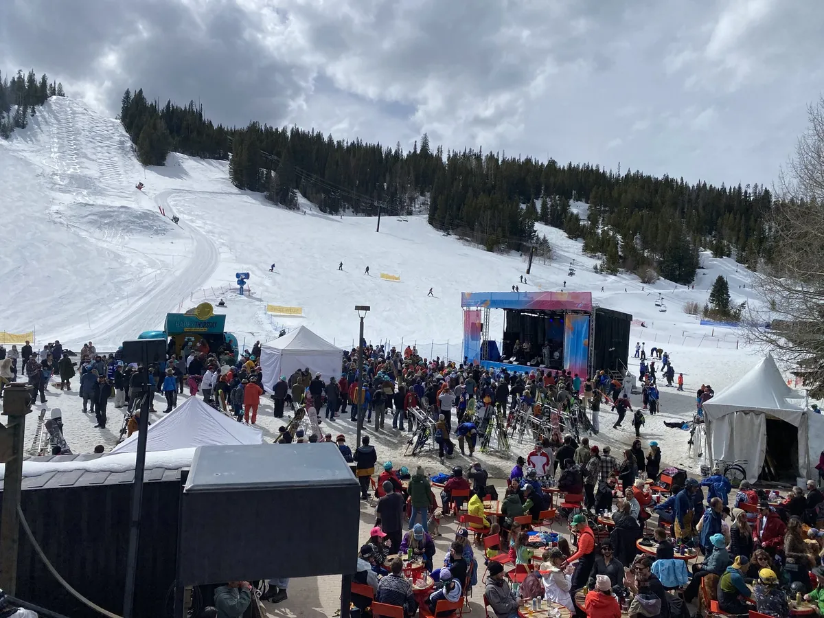 The ski slope above the festival, skiers coming down to the crowd and the stage.