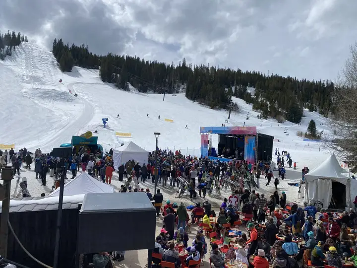 The ski slope above the festival, skiers coming down to the crowd and the stage.
