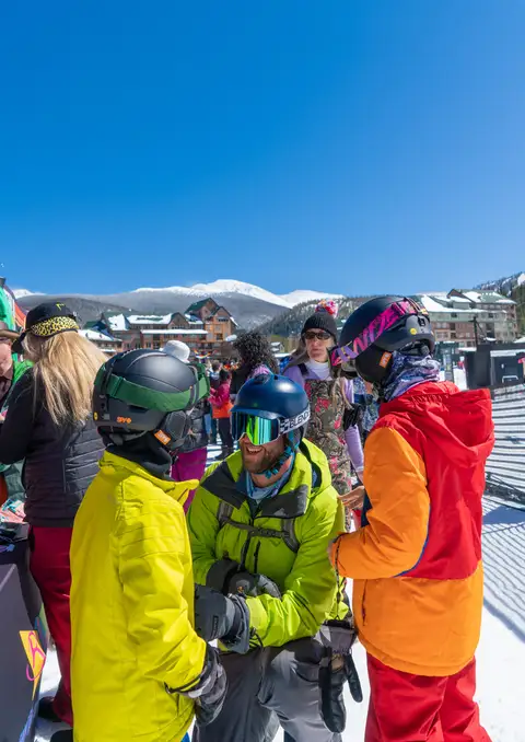 A group in bright ski suits on the snow.